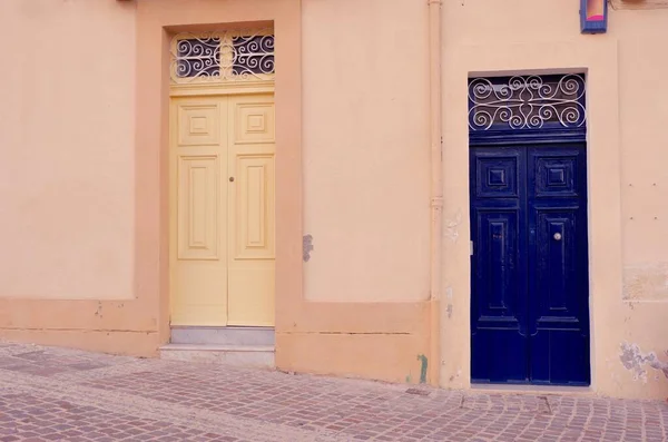 Beżowy Mur Żółtymi Niebieskimi Drzwiami Typowymi Dla Maltańskiej Architektury — Zdjęcie stockowe