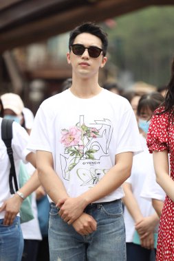 Chinese actor and singer-songwriter Xu Weizhou, also known as Timmy Xu, shows up with glasses and pink T-shirt at the opening ceremony of his new TV series at Hengdian World Studios, Dongyang county-level city, Jinhua city, east China's Zhejiang prov clipart