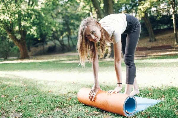 Jovencita Despliega Una Esterilla Yoga Parque Hierba — Foto de Stock