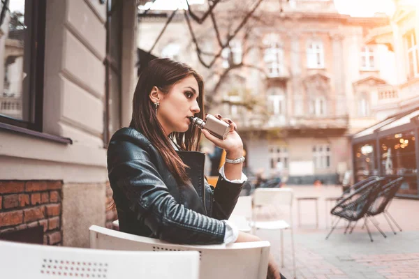 Stylish Girl Smokes Electronic Cigarette Serious Woman Vape Sitting Table — Stok fotoğraf