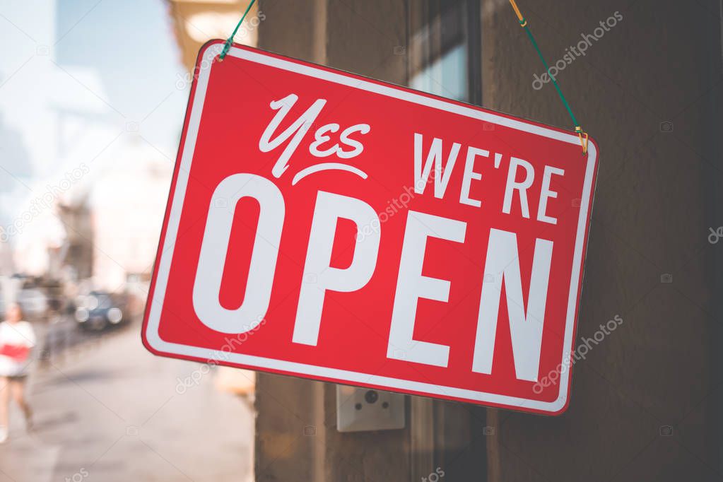 yes we're open sign on the glass of the doors in store. welcome sign at the store