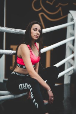 Spor kızı boks ringinde oturuyor.
