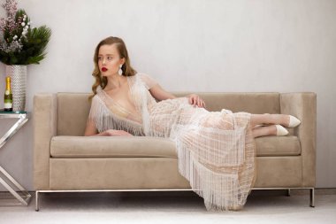 Güzel bir kanepede poz veren muhteşem bir kadın.