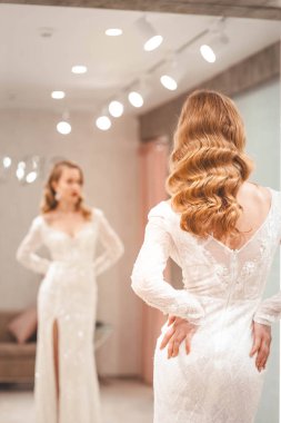 Kız zarif bir gelinlik deniyor.