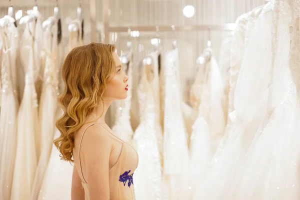 The bride chooses a wedding dress in the store. Girl in the wedding salon