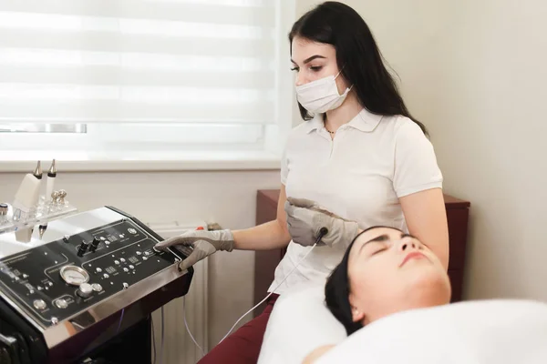 Doctor cosmetologist uses the device for cosmetic procedures.