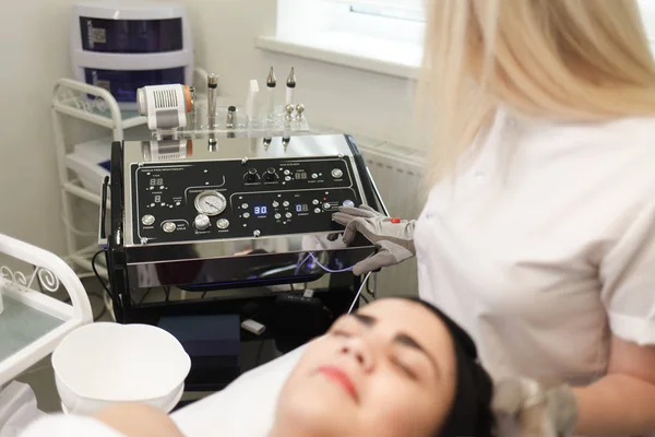 Doctor cosmetologist sets up the device for cosmetic procedures