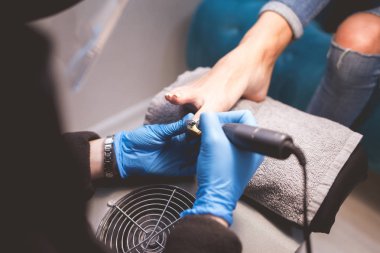 Pedikür ustası oje sürmeden önce tırnaklarını parlatır.