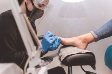  Pedikür ustası, tırnak törpüsü ile tırnak törpülemeden önce yan görünüm uygular