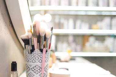 Masaüstünde çeşitli makyaj fırçaları var. Bir sürü makyaj aleti.