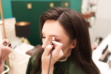 Makyöz müşterisi için kaş makyajı yapıyor. Kaş çizim prosedürü