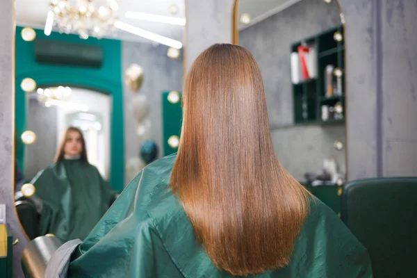 Saç kaplama ameliyatından sonra genç bir kızın parlak ve düz saçları. Keratin ve botoks kılı.