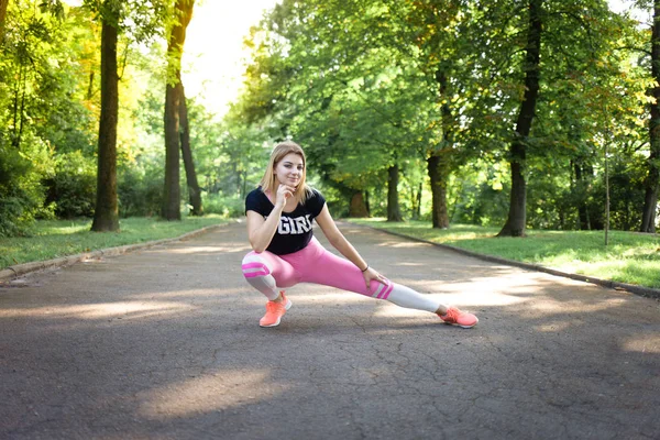 Νεαρή σέξι κοπέλα κάνει διατάσεις. Γυμναστική γυναίκα εκπαίδευση στο πάρκο — Φωτογραφία Αρχείου