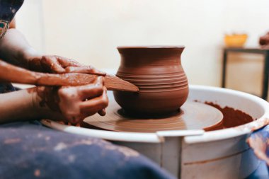 Kız çanak çömlek tekerinin arkasında çalışır ve mükemmel formlarda sürahi oluşturur.