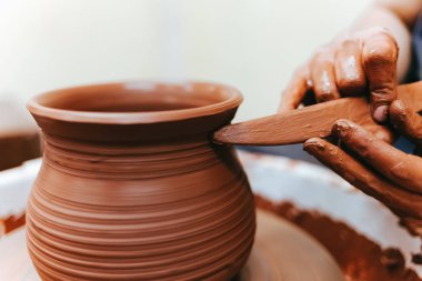 Kız çanak çömlek tekerinin arkasında çalışır ve mükemmel formlarda sürahi oluşturur.