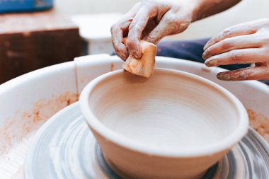 Beyaz kil seramik plaka oluşturma ve oluşturma süreci. Profesyonel çömlekçi kil levhaları modellemekle meşgul. Potter bir atölyede çalışıyor.