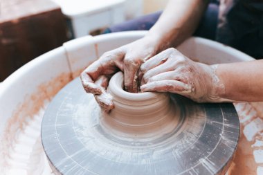 Beyaz kil seramik plaka oluşturma ve oluşturma süreci. Profesyonel çömlekçi kil levhaları modellemekle meşgul. Potter bir atölyede çalışıyor.