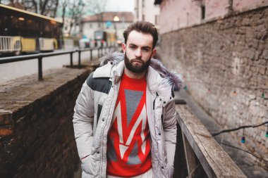 Kışlık ceketli sakallı, dışarıda poz veren şık yakışıklı bir adam. Güzel elbiseli zarif bir adamın portresi.