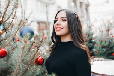 Güzel kız Noel ağacının yanında poz veriyor. Yeni yıla yakın güzel bir kızın portresi.
