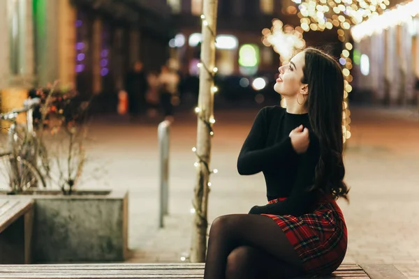 Девочка Сидела Вечерней Улице Украшенной Рождественскими Огнями — стоковое фото