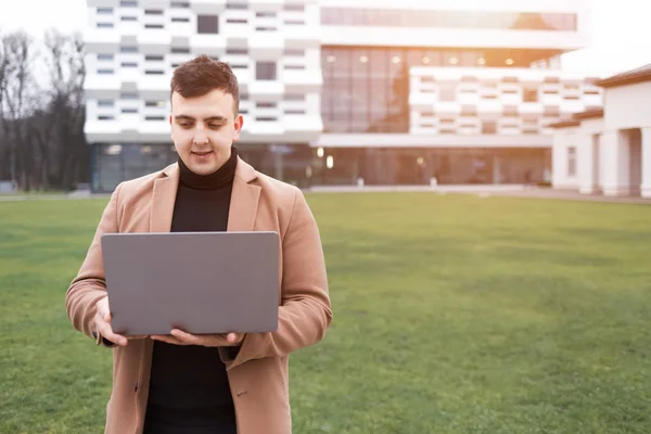 Man Coat Holds Laptop His Hands While Standing Backdrop University — Stock Photo, Image