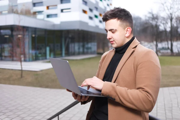 Man Coat Holds Laptop His Hands While Standing Backdrop University — Stock Photo, Image