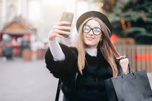 Όμορφη Κοπέλα Σακούλες Στα Χέρια Κάνει Μια Selfie Στο Παρασκήνιο — Φωτογραφία Αρχείου