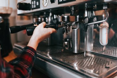 Barista aromatik kahve yapar. Bir kafede kahve makinesinde kahve yapma süreci.