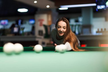 Kumarbaz kadın bilardo kulübünde bilardo oynuyor.