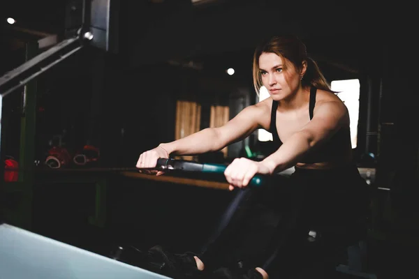 Woman exercise in the gym on a rowing machine