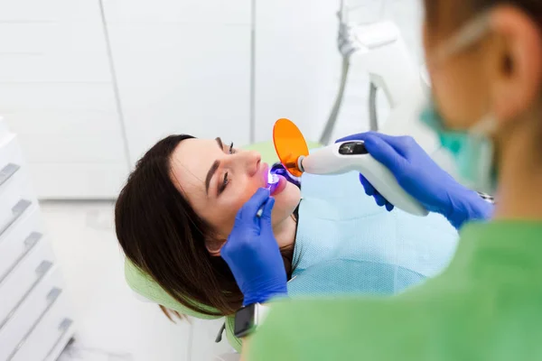 Kız Dişçide Dişçilik Yapıyor Diş Hekimi Hastaların Dişlerinde Ultraviyole Lamba — Stok fotoğraf