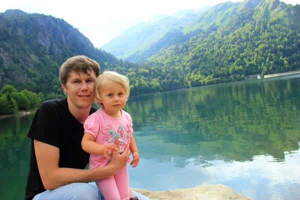 Father and daughter on a lake in the mountains — Stock Photo, Image