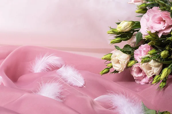 Üzerinde narin çiçekler ve beyaz tüyler olan bir kart.