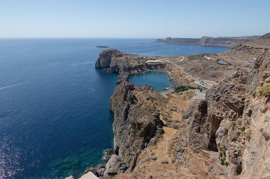 Deniz yüzeyinin ve sahilin panoramik görüntüsü. Kayalık bir uçurumun kenarında. Denizcilik geçmişi Yunanistan, Rodos