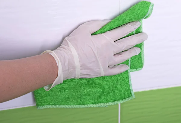 Lastik eldivenlerle banyoyu temizleyen bir kız. Antiseptik etkenlerle yüzeylerin dezenfekte edilmesi. Virüs hijyen konsepti