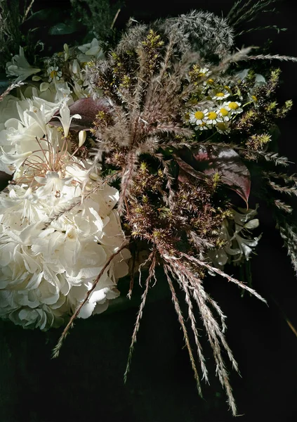 Koyu arkaplan manzaralı bir buket kır çiçeği. Dikey yönelim