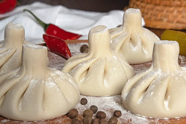 Khinkali, un ve biberle ahşap kesme tahtasındaki Gürcü mutfağının yemeğidir.