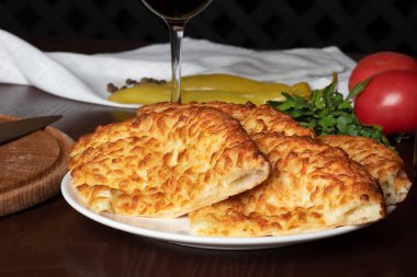 Beyaz tabakta peynirli büyük khachapuri parçaları. Gürcistan un ürünü. Yan görünüm