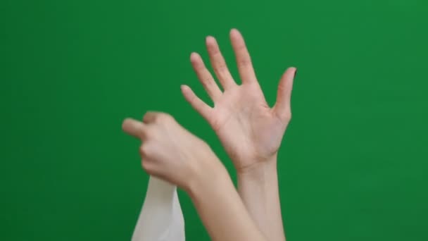 Nahaufnahme. Ärztin zieht weiße Handschuhe an. Chroma Schlüssel Hintergrund. Ärztinnen ziehen sterile Handschuhe an. Laborantin bereitet sich auf Arbeit vor. — Stockvideo