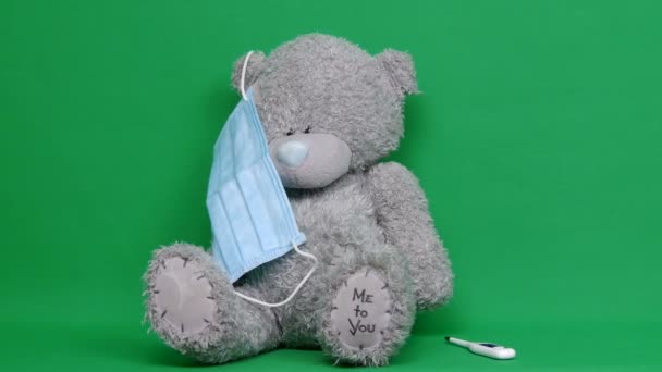 Un ours en peluche. Un nounours malade porte un masque médical sur son visage. Clé chromatique. C'est cool. Concept pour prévenir COVID-19 . — Video