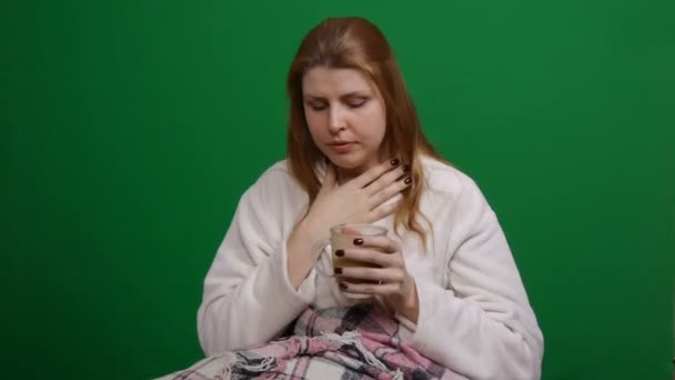 Sick woman wrapped in warm blanket drinking hot tea. Cough. COVID Danger of coronavirus pandemic 2019-ncov. Shot on a green isolated background. Quarantine, fears. Chromakey. — Stock Video