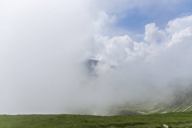 Bulutlu ve mavi gökyüzü olan dağ manzarası