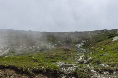 Bulutlu ve mavi gökyüzü olan dağ manzarası