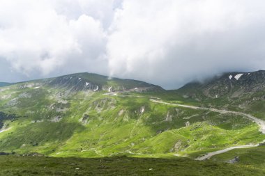 Bulutlu ve mavi gökyüzü olan dağ manzarası