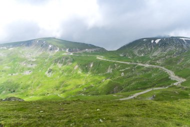 Yeşil çimenler ve dağlarla kaplı dağ manzarası