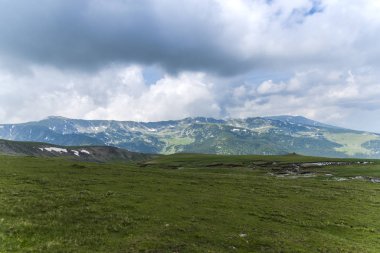 Bulutlu ve mavi gökyüzü olan dağ manzarası