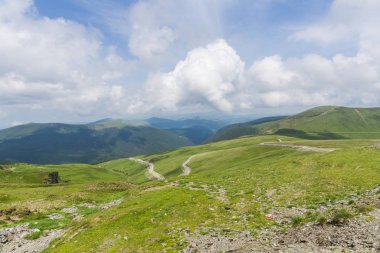 Bulutlu ve mavi gökyüzü olan dağ manzarası