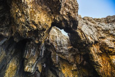 Mağarası olan bir kaya duvarına yakın.
