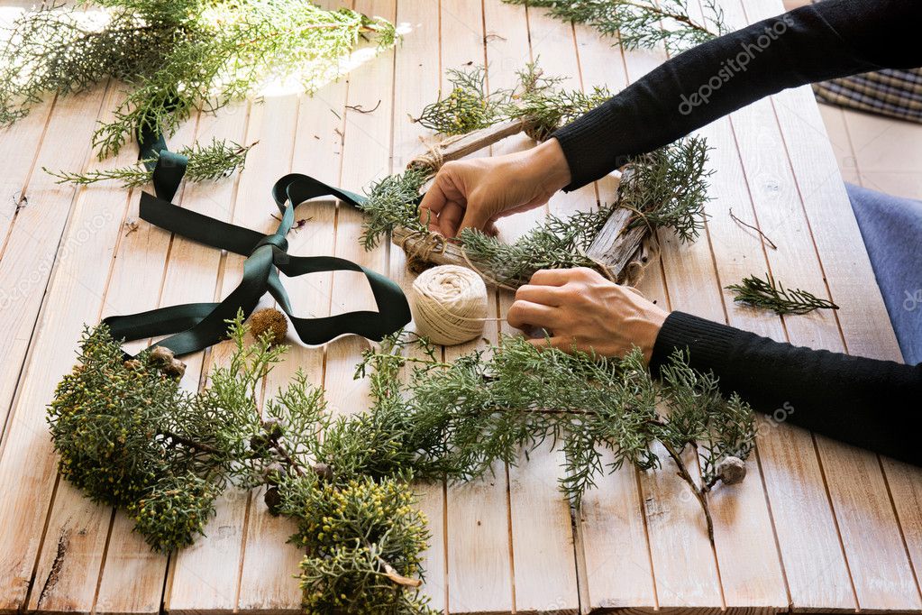 Florist at work: Creating a wooden wreath with christmas  