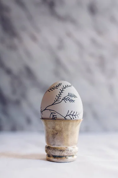 Œuf de Pâques décoré de branches, sur récipient en argent — Photo